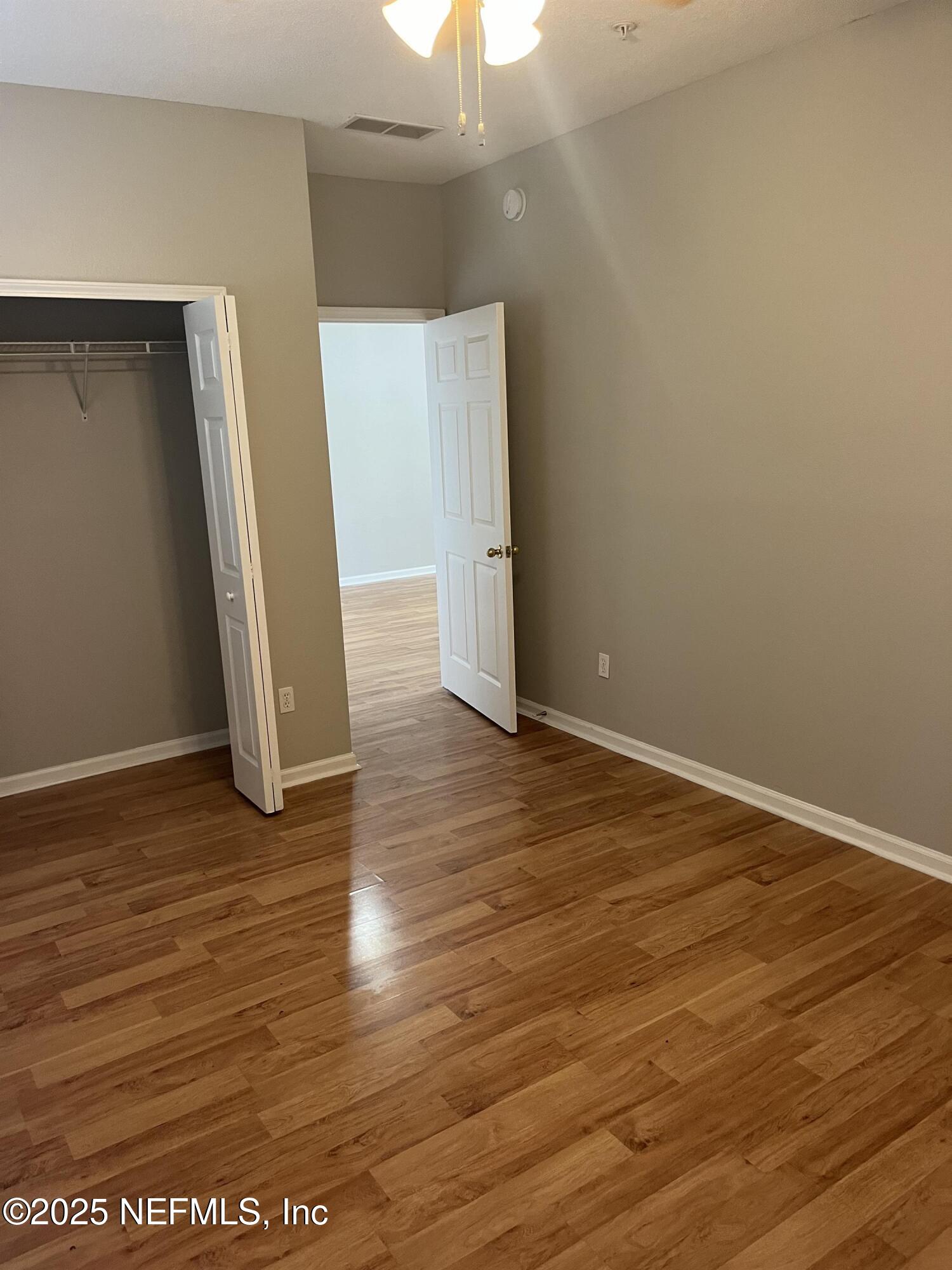 3680 Kirkpatrick Circle, Unit 3 Jacksonville, FL 32210 - Photo 4 of 7 an empty room with wooden floor and entrance