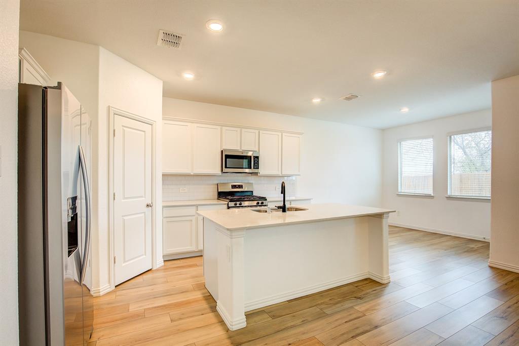 532 Ranchito Pass Haslet, TX 76052 - Photo 11 of 38 a kitchen with white cabinets and stainless steel appliances