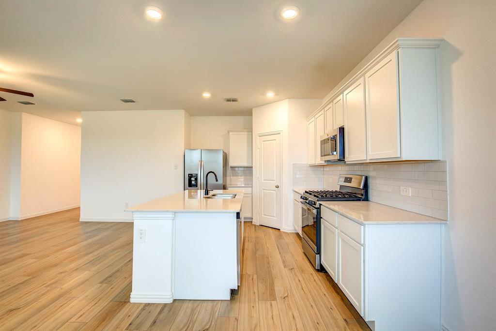 532 Ranchito Pass Haslet, TX 76052 - Photo 13 of 38 a large kitchen with stainless steel appliances a lot of counter space and wooden floor