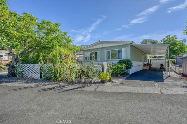 a front view of a house with a yard and potted plants