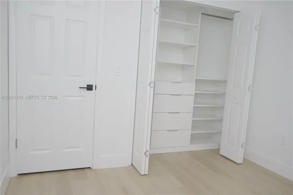 a view of walk in closet with empty racks
