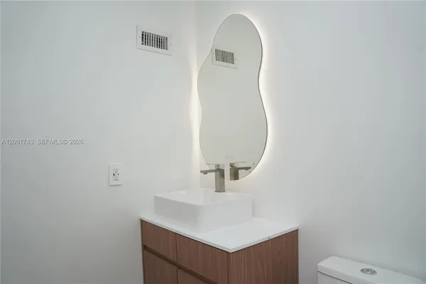 a bathroom with a sink a toilet and mirror