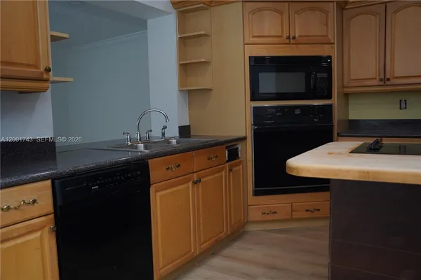 a kitchen with stainless steel appliances granite countertop a sink stove and cabinets
