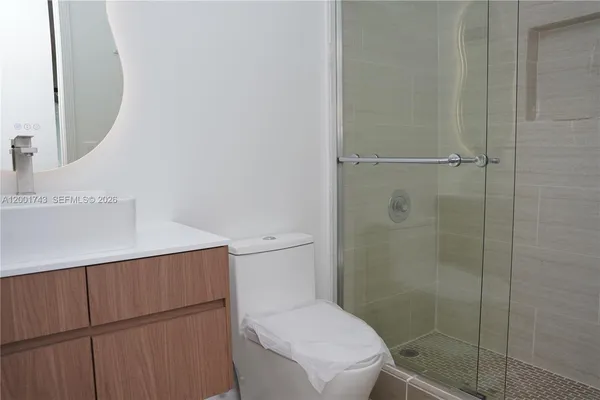 a bathroom with a toilet and a shower