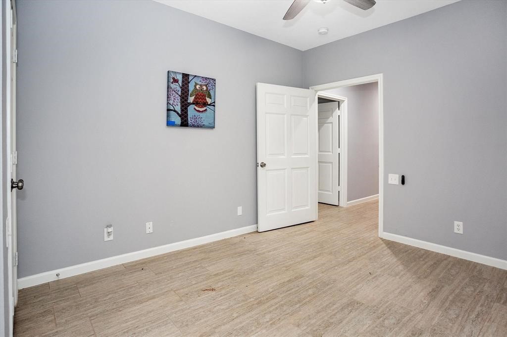 24600 Nine Bar Road Hempstead, TX 77445 - Photo 13 of 26 an empty room with wooden floor and ceiling fan