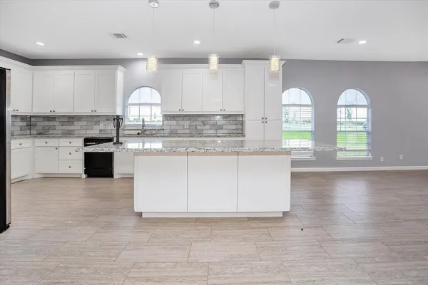 a large kitchen with stainless steel appliances granite countertop a stove a sink and a microwave