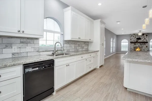 a kitchen with granite countertop cabinets stainless steel appliances a sink and a window