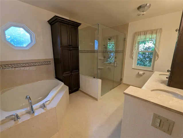 a bathroom with a tub sink and mirror