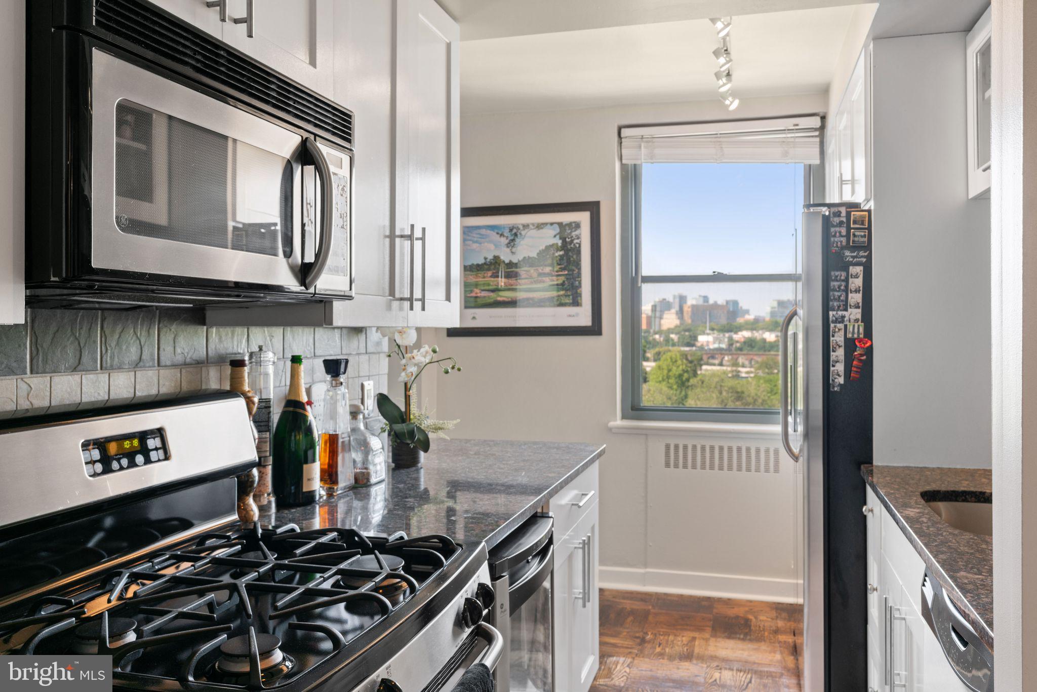 2601 Pennsylvania Avenue, Unit 846 Philadelphia, PA 19130 - Photo 14 of 40 a kitchen with stainless steel appliances a stove a sink and a microwave