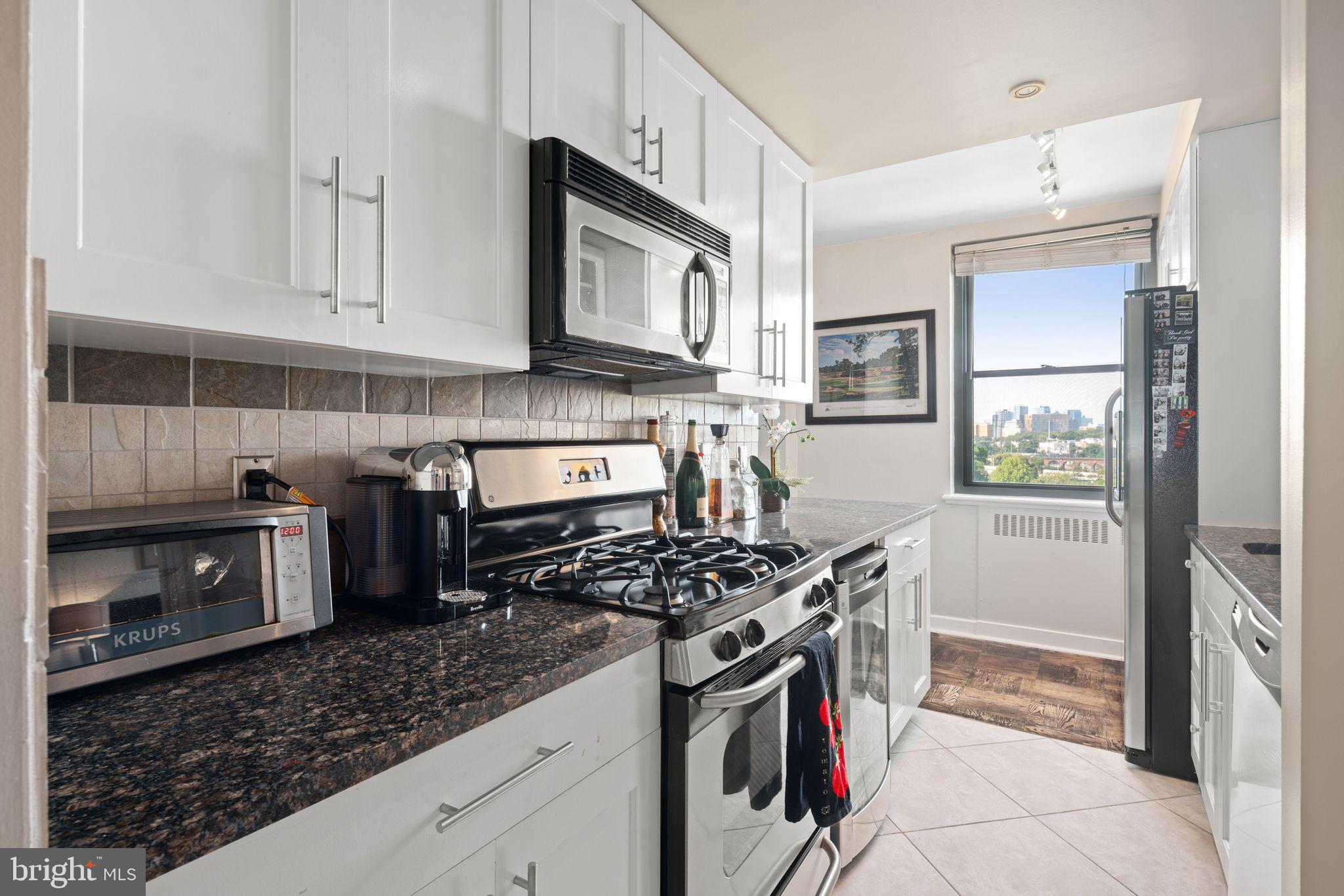 2601 Pennsylvania Avenue, Unit 846 Philadelphia, PA 19130 - Photo 15 of 40 a kitchen with stainless steel appliances granite countertop a stove and a sink
