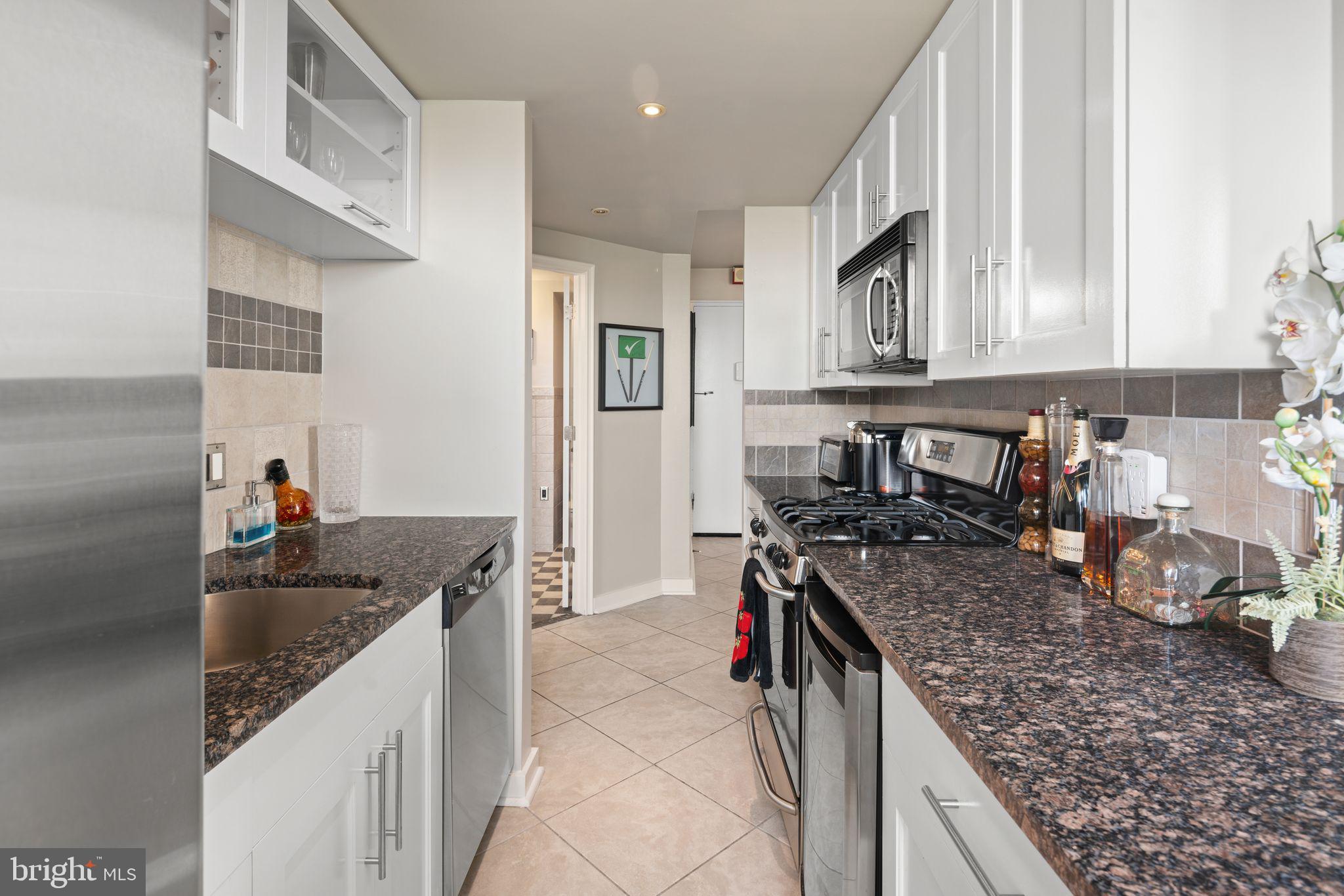 2601 Pennsylvania Avenue, Unit 846 Philadelphia, PA 19130 - Photo 18 of 40 a kitchen with granite countertop a sink stove and cabinets
