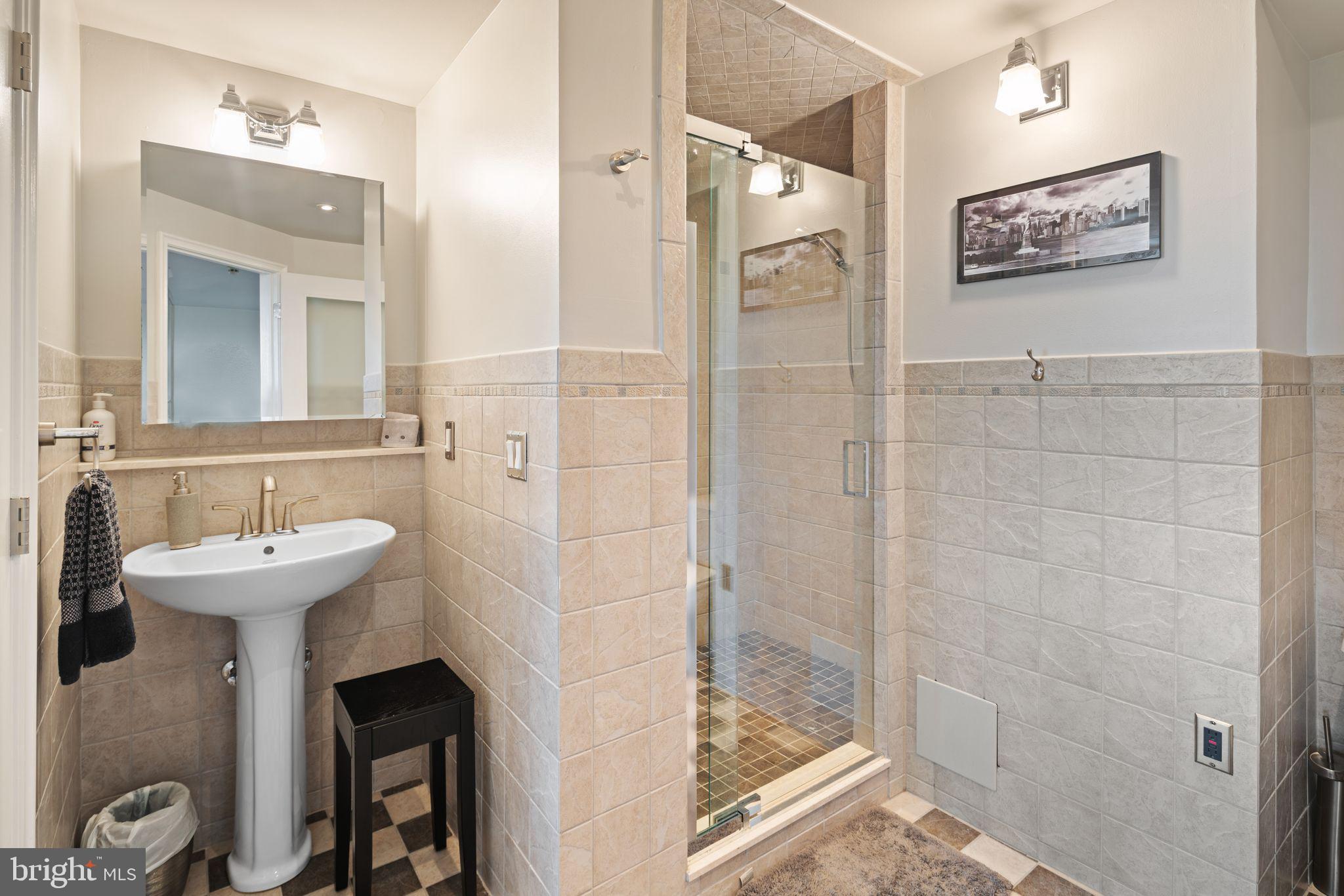 2601 Pennsylvania Avenue, Unit 846 Philadelphia, PA 19130 - Photo 25 of 40 a bathroom with a sink mirror and shower