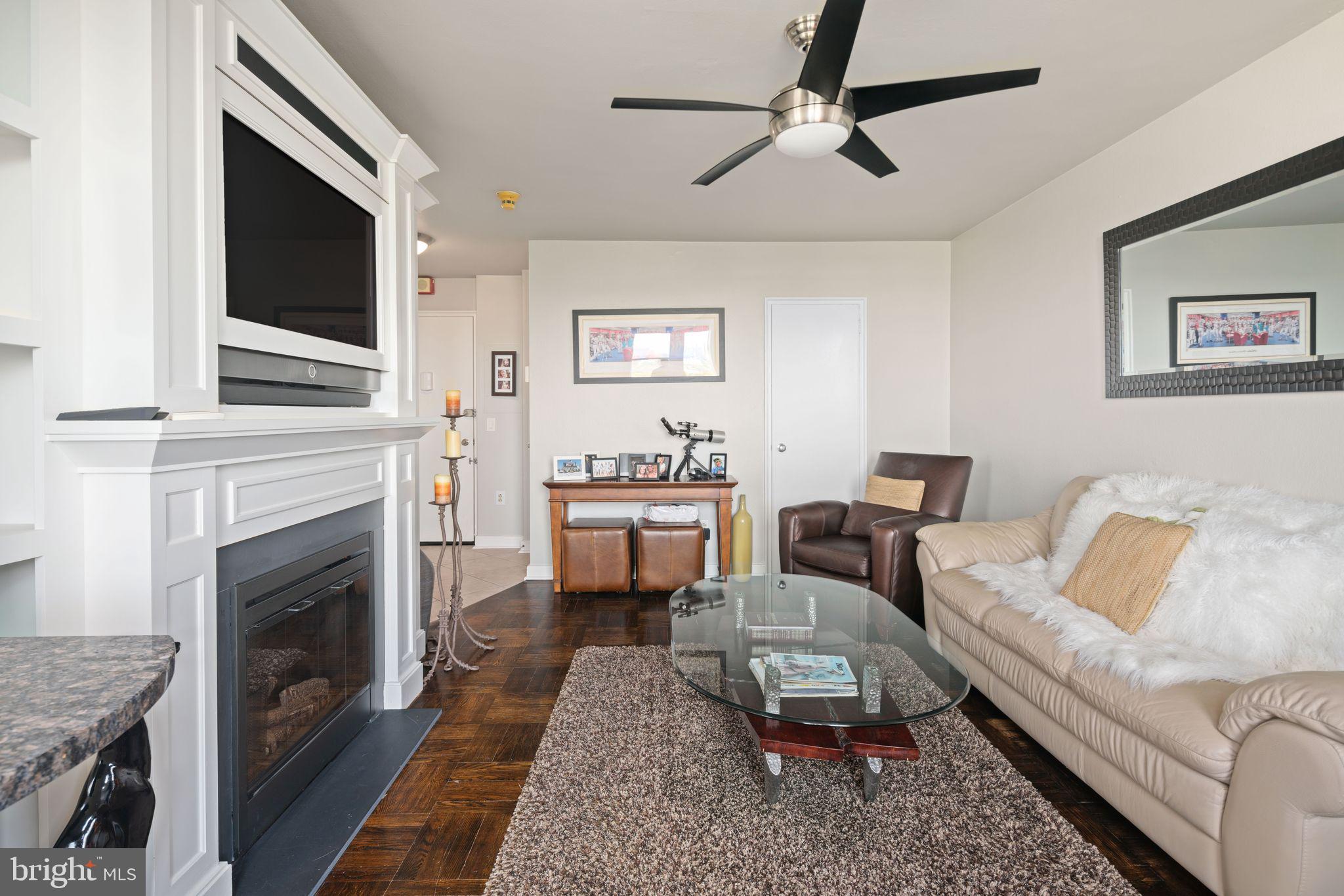 2601 Pennsylvania Avenue, Unit 846 Philadelphia, PA 19130 - Photo 6 of 40 a living room with furniture a flat screen tv and a fireplace