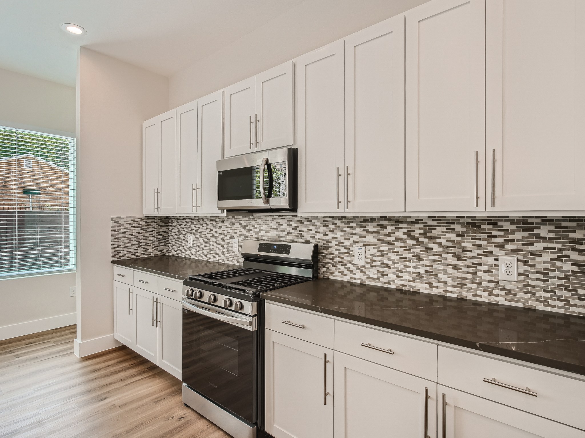6919 Bethune Avenue, Unit B Austin, TX 78752 - Photo 6 of 17 a kitchen with granite countertop white cabinets and stainless steel appliances