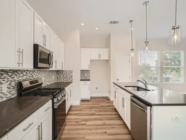 a kitchen with granite countertop a sink and a stove
