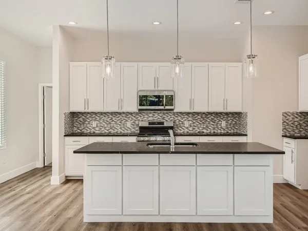 a kitchen with white cabinets and stainless steel appliances