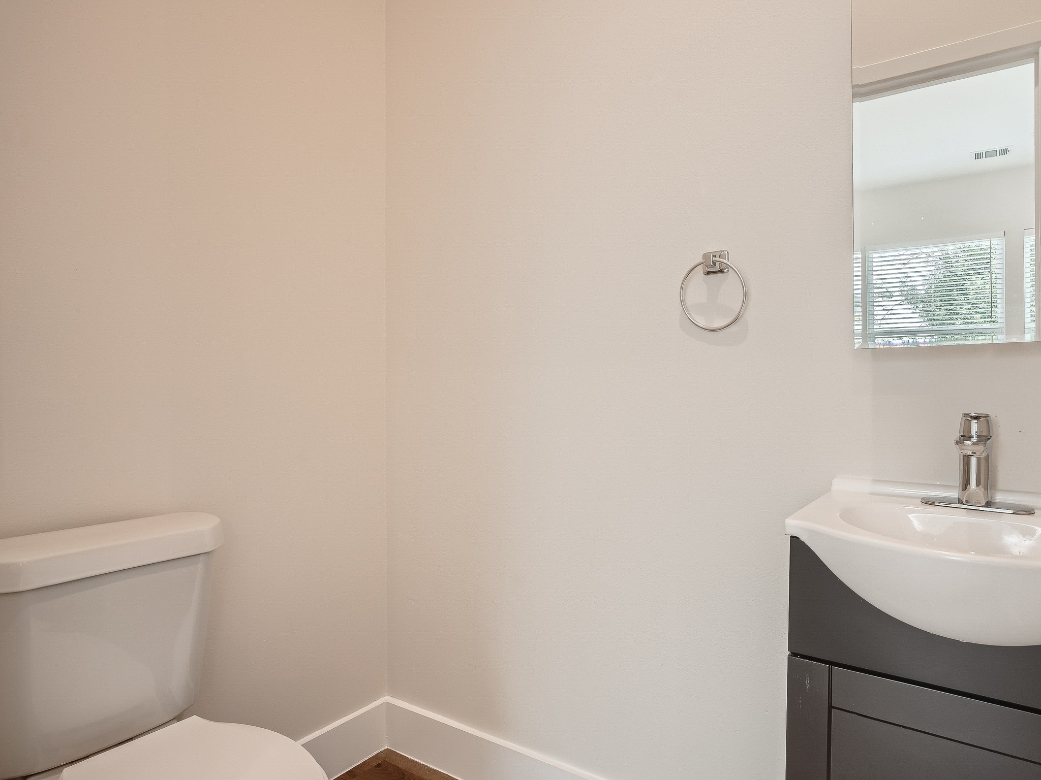 6919 Bethune Avenue, Unit B Austin, TX 78752 - Photo 9 of 17 a bathroom with a toilet a sink and mirror