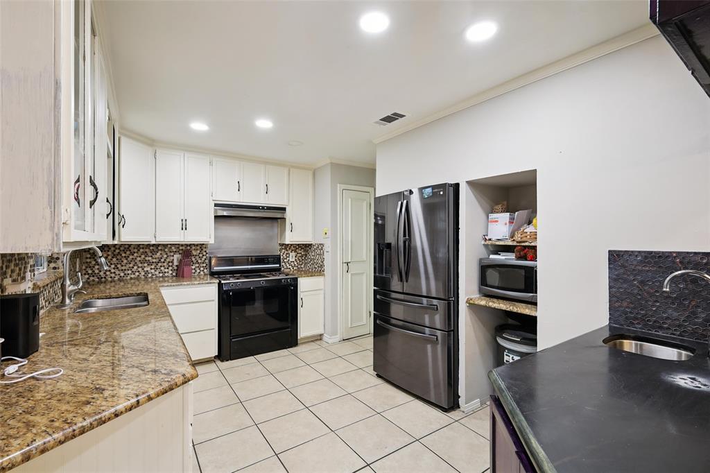 10505 Ferguson Road Dallas, TX 75228 - Photo 11 of 29 a kitchen with granite countertop a refrigerator and a stove top oven