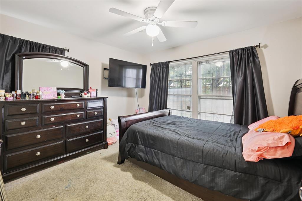 10505 Ferguson Road Dallas, TX 75228 - Photo 22 of 29 a bedroom with a bed and a mirror on dresser