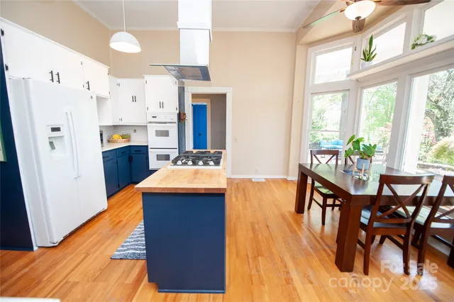 a kitchen that has a table chairs in it and wooden floor