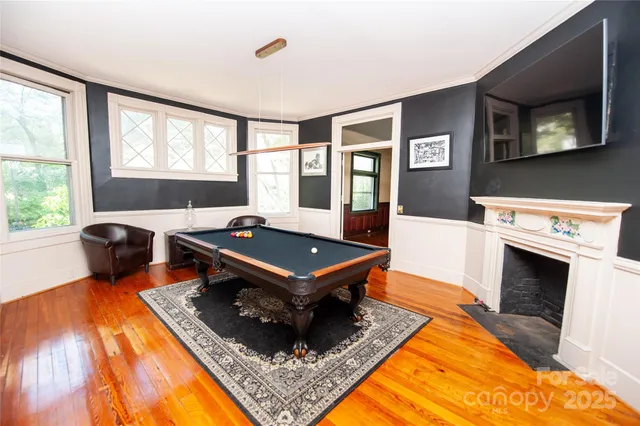 a living room with furniture pool table and a fireplace