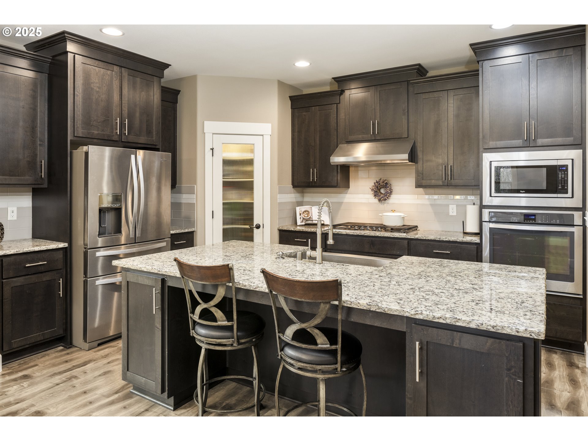 4841 North 8th Street Ridgefield, WA 98642 - Photo 8 of 48 a kitchen with granite countertop a table chairs stove refrigerator and cabinets