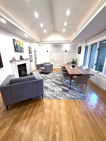 a living room with furniture a bookshelf and a window
