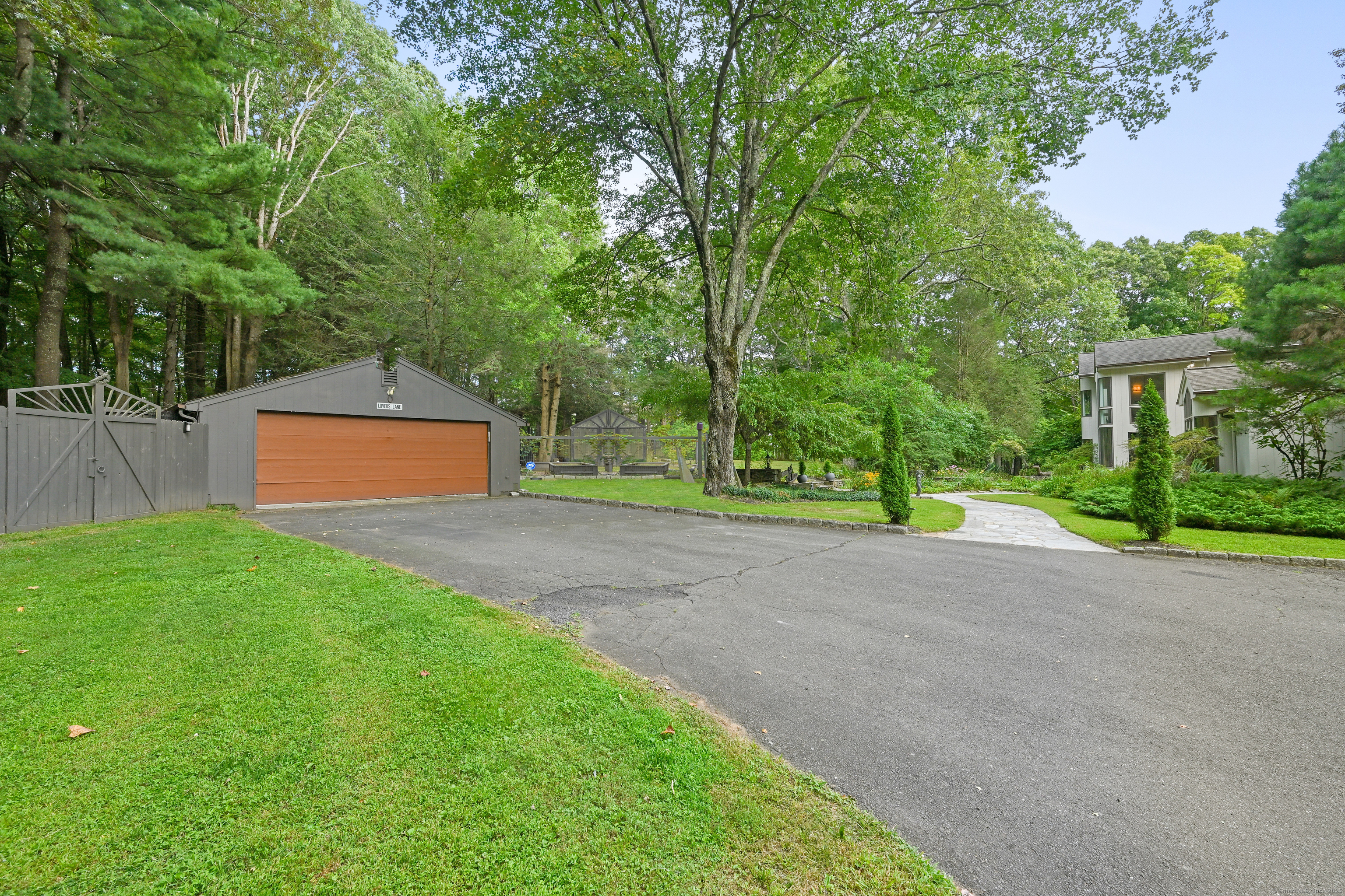 61 Marchant Road Redding, CT 06896 - Photo 36 of 38 a backyard of a house with plants and large trees