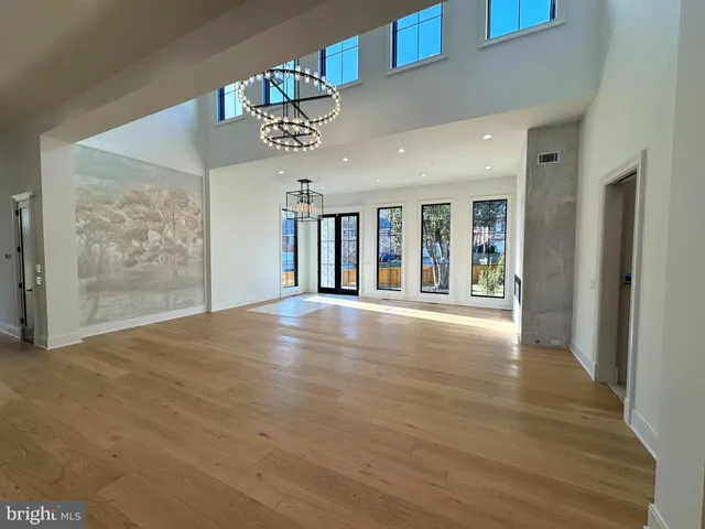 a view of a hallway with wooden floor and a living room