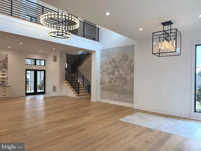 a view of a hallway with wooden floor and a living room