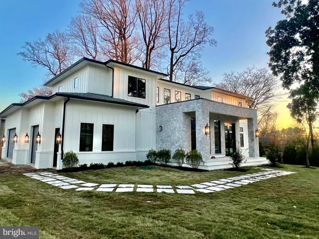 a view of a white house with a big yard and large trees