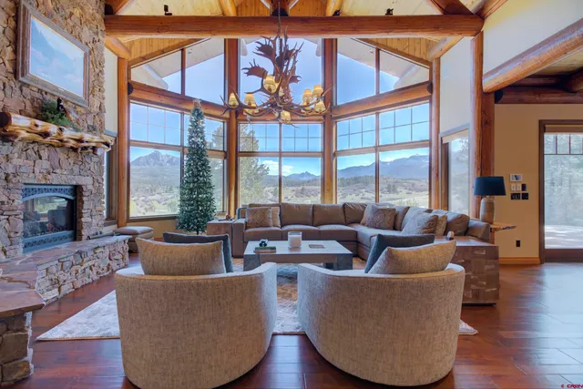 a living room with furniture a fireplace and a chandelier