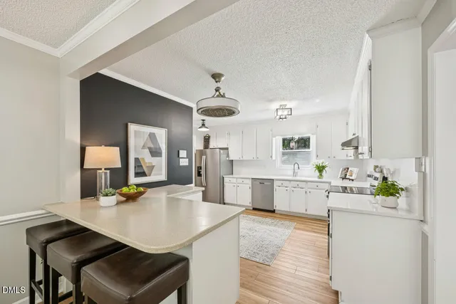 a kitchen with a sink a counter top space and living room area