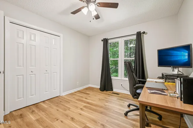 a view of a workspace with furniture and a window