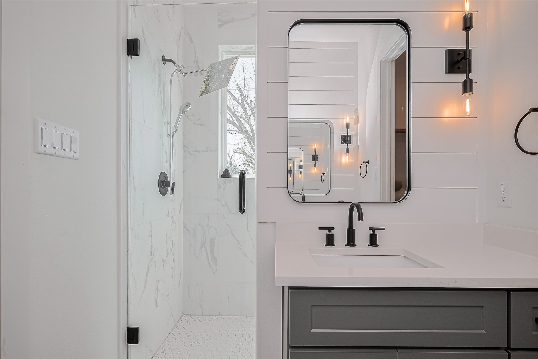 2518 Terry Street Houston, TX 77009 - Photo 14 of 17 Modern vanity area with matte black fixtures and designer lighting, with the frameless glass shower located directly behind the vanity area.