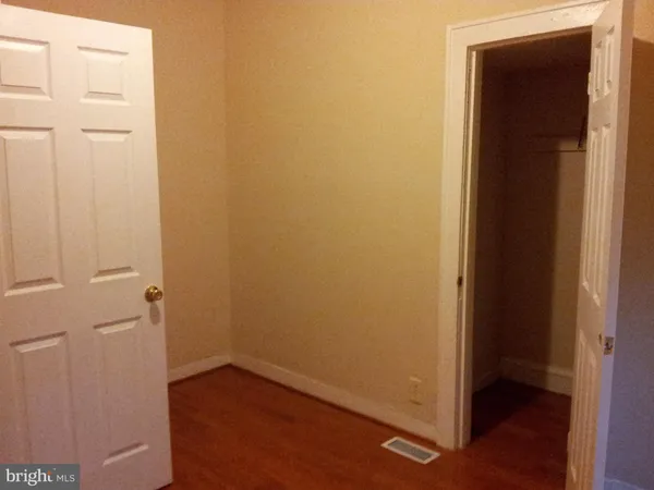 an empty room with wooden floor and closet