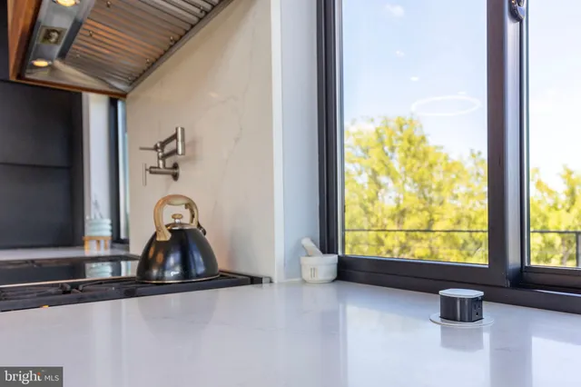 a view of kitchen with stainless steel appliances granite countertop a refrigerator and a sink
