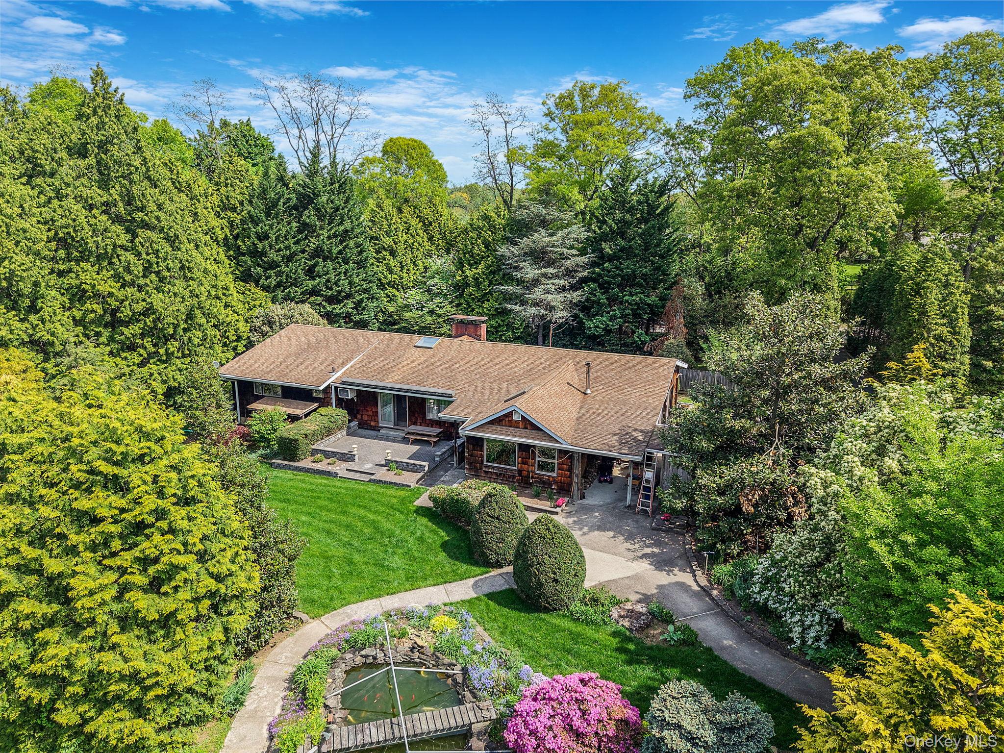 280 Deforest Road North Dix Hills, NY 11746 - Photo 1 of 37 an aerial view of a house with garden space and trees