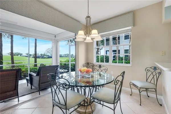 a dining room with furniture large windows and outdoor view