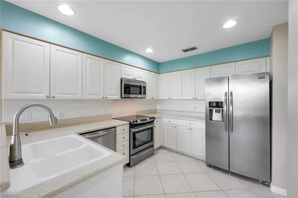 a kitchen with stainless steel appliances granite countertop a sink a stove and a refrigerator