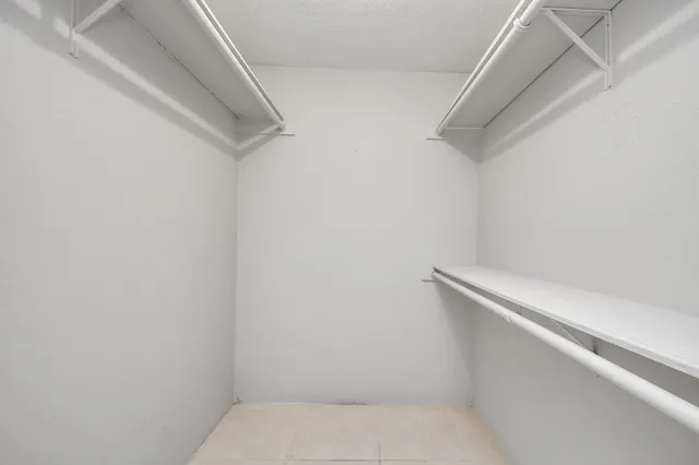an empty room with closet and a ceiling fan