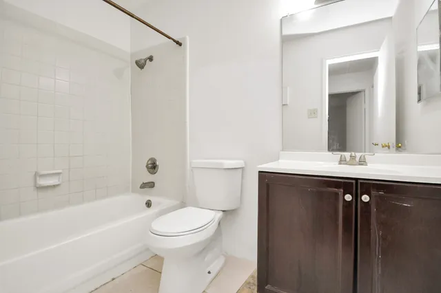 an empty room with windows and chandelier fan
