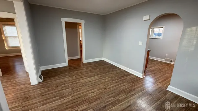 an empty room with wooden floor and mirror