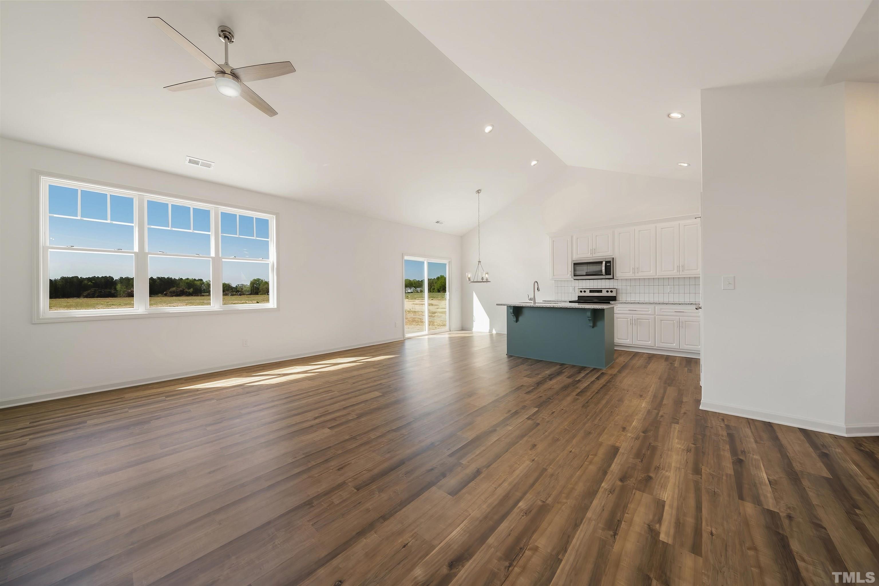 4107 Needham Road Bailey, NC 27807 - Photo 6 of 24 a view of a room with wooden floor and a kitchen space