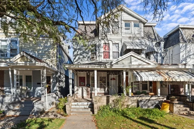 a front view of a house with sitting area and garden