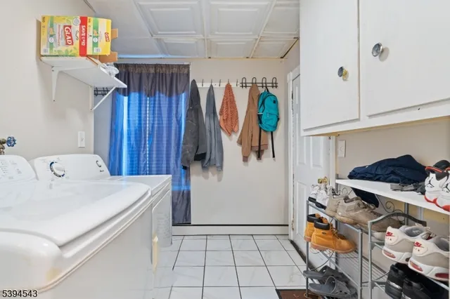 a utility room with stainless steel appliances wooden floor and window