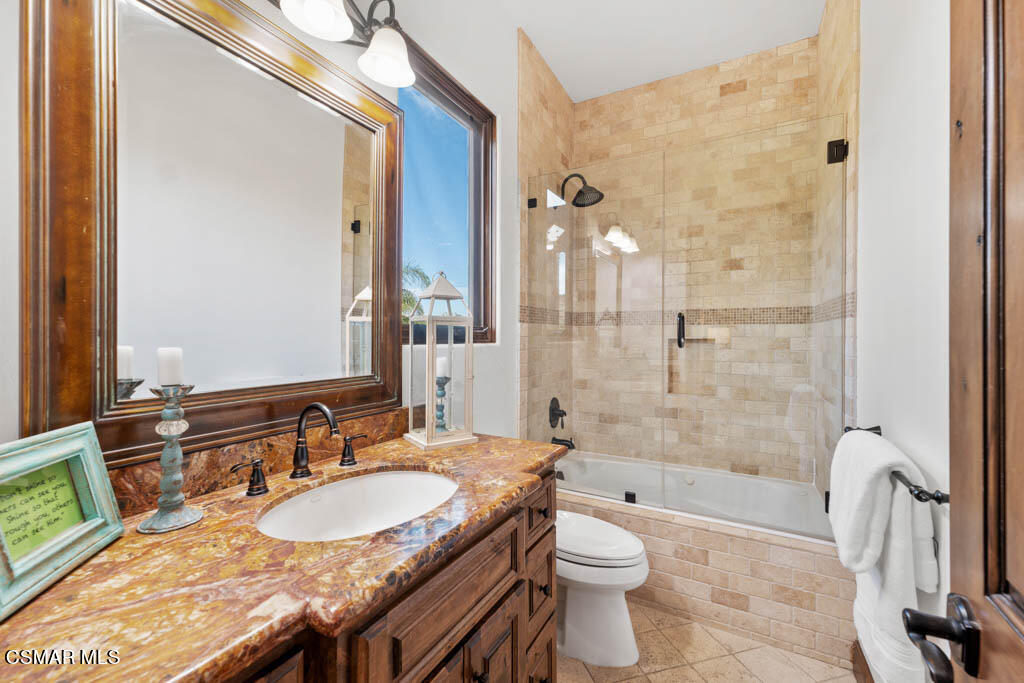 8577 Happy Camp Road Moorpark, CA 93021 - Photo 34 of 96 a bathroom with a granite countertop sink a toilet a mirror and shower