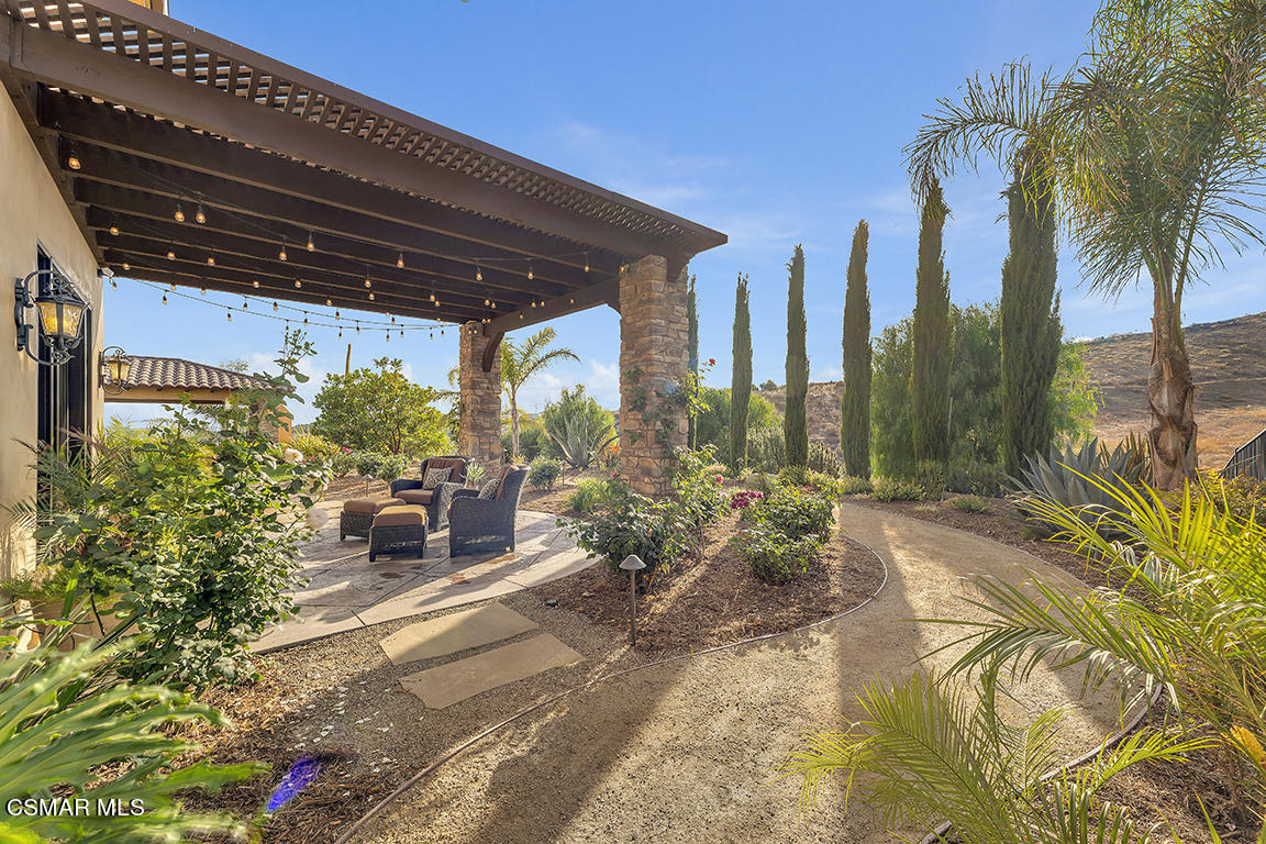 8577 Happy Camp Road Moorpark, CA 93021 - Photo 76 of 96 a view of a patio with table and chairs potted plants and palm tree