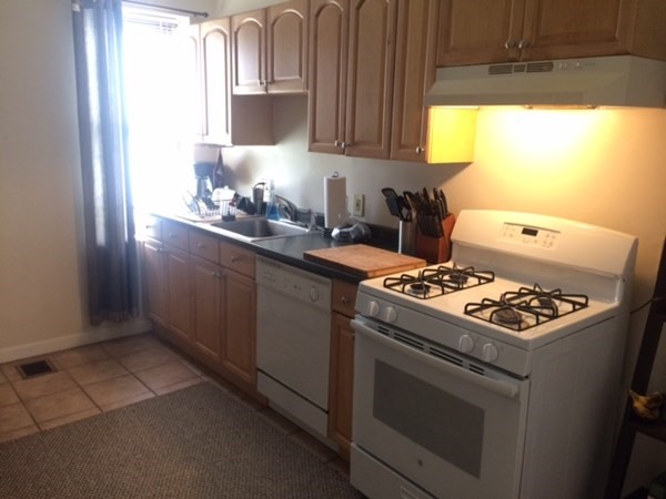 281 West 3rd Street, Unit 1 Boston, MA 02127 - Photo 5 of 11 a kitchen with kitchen island a sink stove and cabinets