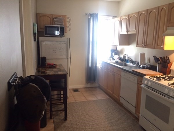 281 West 3rd Street, Unit 1 Boston, MA 02127 - Photo 6 of 11 a kitchen with a refrigerator and a stove top oven